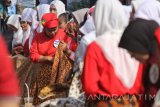 Sejumlah perempuan belajar tata cara mengenakan kain batik saat acara Gelar Berkain Nuasantara 2017 di Surabaya, Jawa Timur, Minggu (13/8). Kegiatan yang digagas oleh komunitas Bangga Berkain Nusantara tersebut diikuti oleh 200 perempuan guna melestarikan kain batik dan tata cara pemakainnya sebagai khazanah kebudayaan Indonesia. Antara Jatim/Moch Asim/zk/17