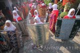 Sejumlah perempuan belajar tata cara mengenakan kain batik saat acara Gelar Berkain Nuasantara 2017 di Surabaya, Jawa Timur, Minggu (13/8). Kegiatan yang digagas oleh komunitas Bangga Berkain Nusantara tersebut diikuti oleh 200 perempuan guna melestarikan kain batik dan tata cara pemakainnya sebagai khazanah kebudayaan Indonesia. Antara Jatim/Moch Asim/zk/17