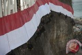 Anggota Brimob Polda Bali dan Basarnas mengibarkan Bendera Merah Putih terpanjang di dinding tebing Pantai Pandawa, Badung, Bali, Senin (14/8). Pengibaran Bendera Merah Putih sepanjang 800 meter tersebut untuk memperingati HUT ke-72 Proklamasi Kemerdekaan Indonesia, memperkuat nasionalisme dan sekaligus memecahkan rekor MURI. Antara Bali/Nyoman Budhiana/nym/2017.