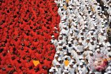 Anggota polisi membentuk formasi merah putih saat pengibaran Bendera Merah Putih terpanjang di dinding tebing Pantai Pandawa, Badung, Bali, Senin (14/8). Pengibaran Bendera Merah Putih sepanjang 800 meter tersebut untuk memperingati HUT ke-72 Proklamasi Kemerdekaan Indonesia, memperkuat nasionalisme dan sekaligus memecahkan rekor MURI. Antara Bali/Nyoman Budhiana/nym/2017.