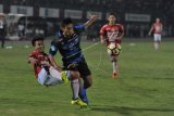 Pesepak bola Madura United (MU) Guntur Ariyadi (tengah) dan pesepak bola Bali United (BU) Taufiq (kiri) berebut bola dalam lanjutan laga Gojek Traveloka Liga 1 di Stadion I Wayan Dipta, Gianyar, Bali, Minggu (13/8). Bali United menang dengan skor 5-2 atas Madura United. ANTARA FOTO/Saiful Bahri/kye/17