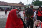 Seorang peserta mengikuti lomba mengambil uang logam tertanam di semangka menggunakan mulut di halaman Mako Brimob Polda Kaltim di Balikpapan, Senin (14/8/2017). Menurut Dansat Brimob Polda Kaltim Kombes Pol Heri Heryandi, berbagai lomba digelar untuk memeriahkan perayaan HUT ke-72 Kemerdekaan RI. (ANTARA Kaltim/HO/Arwani-Satbrimob Kaltim)