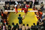 Sejumlah pelajar mengikuti lomba 'Gebuk Bantal' di atas kolam buatan di halaman SD Muhammadiyah 4 Pucang Surabaya, Jawa Timur, Rabu (16/8). Berbagai kegiatan lomba yang bersifat menghibur digelar berbagai kalangan masyarakat untuk menyemarakkan HUT Ke-72 RI. Antara Jatim/Didik Suhartono/zk/17