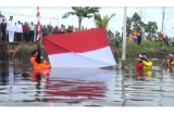 Warga Kelurahan Siantan Hulu, Kecamatan Pontianak Utara, Provinsi Kalimantan Barat, menggelar upacara memperingati HUT ke-72 Republik Indonesia dengan mengibarkan bendera merah putih di dalam Parit. (Foto Antara Kalbar/Andilala)