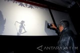 Penonton memotret Pagelaran wayang kulit yang dibawakan dalang Ardi Purbo Antoro dengan lakon Satria Tripama dari balik layar di Klenteng En Ang Kiong, Malang, Jawa Timur, Rabu (16/7) malam. Pagelaran wayang kulit tersebut sengaja diadakan sebagai bahan renungan atau refleksi peringatan HUT Kemerdekaan RI Ke-72 melalui keragaman budaya. Antara Jatim/Ari Bowo Sucipto/zk/17.