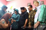 Gubernur Jatim Soekarwo (kedua kanan) didampingi Nina Kirana Soekarwo (tengah) dan Direktur UNICEF untuk Area Jawa Arie Rukmantara (ke-kanan) dan perwakilan Unicef Pusat untuk Indonesia Gunilla Olsson (kanan) menyaksikan pemberian vaksin Measles Rubella (MR) atau vaksin   campak dan rubella pada siswa di SMPN 1 Torjun, Sampang, Jawa Timur, Sabtu (19/8). Pemberian vaksin terhadap anak usia 9 bulan hingga 15 tahun di daerah itu mencapai 64 persen pada hari ke-19 dari total anak sebanyak 257 ribu lebih atau 27 persen dari keselurahan penduduk Kabupaten Sampang dan ditargetkan rampung dalam 32 hari.  Antara Jatim/Saiful Bahri/zk/17