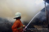 Tim PMK menyemprotkan air untuk memadamkan kobaran api yang membakar sebuah gudang tebu di Tulungagung, Jawa Timur, Minggu (20/8). Kebakaran gudang tempat penyimpanan tebu di salah satu pabrik gula tebu rakyat itu diduga akibat kelalaian pekerja yang membakar sampah di sekitar lokasi kejadian. Antara Jatim/Destyan Sujarwoko/zk/17