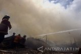 Tim PMK menyemprotkan air untuk memadamkan kobaran api yang membakar sebuah gudang tebu di Tulungagung, Jawa Timur, Minggu (20/8). Kebakaran gudang tempat penyimpanan tebu di salah satu pabrik gula tebu rakyat itu diduga akibat kelalaian pekerja yang membakar sampah di sekitar lokasi kejadian. Antara Jatim/Destyan Sujarwoko/zk/17