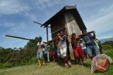 Warga bergotong royong memindahkan sebuah rumah dengan cara menggotongnya di Desa Vatunonju, Kecamatan Biromaru, Kabupaten Sigi Sulawesi Tengah, Minggu (20/8). Warga di desa itu masih mempertahankan tradisi gotong royong yang telah berangsung sejak turun temurun untuk membantu sesama warga lainnya. ANTARAFOTO/Basri Marzuki/wdy/2017.