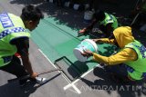 Pekerja melakukan pewarnaan aspal sebagai jalur sepeda di salah satu jalan protokol di Kota Kediri, Jawa Timur, Senin (21/8). Jalur hijau tersebut merupakan salah satu wujud pembangunan Rute Aman Selamat Sekolah (RASS) yang dicanangkan oleh kementerian Perhubungan guna menekan angka kecelakaan pada anak yang pada tahun 2016 mencapai 20 persen dari jumlah total korban kecelakaan lalulintas. Antara Jatim/Prasetia Fauzani/zk/17