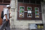 Pengguna jalan melihat foto yang dipajang di pinggir jalan dalam Pameran Foto bertajuk 'Lebur' di Malang, Jawa Timur, Selasa (22/8). Pameran yang berlangsung selama empat hari tersebut menampilkan delapan foto story dari para fotografer muda sebagai upaya mendekatkan seni fotografi pada masyarakat. Antara Jatim/Ari Bowo Sucipto/zk/17.