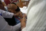 Dokter menyuntikkan vaksin campak dan rubella (measles and rubella/MR) kepada anak dengan faktor risiko kondisi ikutan pasca imunisasi (KIPI) di RSUD dr Iskak, Tulungagung, Jawa Timur, Rabu (23/8). Puluhan anak usia sekolah mulai TK-SD hingga SMP di daerah itu terpaksa dirujuk ke rumah sakit untuk mengikuti program imunisasi campak dan rubella karena memiliki riwayat klinis spesifik seperti jantung lemah, alergi obat, talasemia dan risiko penyakit ikutan lain pasca imunisasi sehingga memerlukan penanganan khusus di tingkat RSUD. Antara Jatim/Destyan Sujarwoko/zk/17