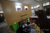 Mahasiswa jurusan teknik elektro industri Politeknik Elektronika Negeri Surabaya (PENS) Elang Utomo (kanan) dan Wahyu Setiawan (kiri) memeriksa kondisi mobil listrik 