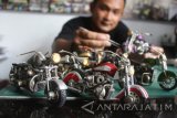 Pengrajin membuat miniatur motor Harley Davidson berbahan daur ulang dari pernik tekstil untuk dijual dengan harga Rp200 ribu hingga 250 ribu rupiah di Kepanjen, Malang, Jawa Timur, Kamis (24/8). Menurut pengrajin setempat, permintaan miniatur motor harley turun hampir 100 persen akibat serbuan produk mainan motor dari China yang terbuat dari plastik. Antara jatim/Ari Bowo Sucipto/zk/17.