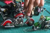 Pengrajin membuat miniatur motor Harley Davidson berbahan daur ulang dari pernik tekstil untuk dijual dengan harga Rp200 ribu hingga 250 ribu rupiah di Kepanjen, Malang, Jawa Timur, Kamis (24/8). Menurut pengrajin setempat, permintaan miniatur motor harley turun hampir 100 persen akibat serbuan produk mainan motor dari China yang terbuat dari plastik. Antara jatim/Ari Bowo Sucipto/zk/17.