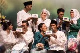 Pasangan pengantin memakan kue saat Nikah Massal PKB Mantu yang diselenggarakan DPP Partai Kebangkitan Bangsa (PKB) di Jakarta, Jumat (25/8/2017). Sebanyak 143 pasangan pengantin muda hingga usia lanjut mengikuti nikah massal tersebut. (ANTARA FOTO/M Agung Rajasa)