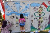Warga menyelesaikan pembuatan mural di atas media anyaman bambu di Kelurahan Kebonsari, Sumbersari, Jember, Jawa Timur, Sabtu (26/8). Mural di kawasan perkampungan itu untuk memeriahkan HUT ke-72 Kemerdekaan RI. Antara Jatim/Seno/zk/17.