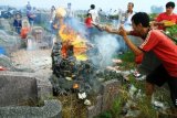 Warga Tionghoa membakar uang kertas mainan saat menjalani prosesi sembahyang kubur di pemakaman Yayasan Bhakti Suci, Sungai Raya, Kabupaten Kubu Raya, Kalbar, Minggu (27/8). Prosesi sembahyang kubur Cit Gwee Puah yang rutin dilaksanakan setiap tanggal 1 hingga 15 bulan tujuh tahun Imlek tersebut, akan diakhiri dengan pembakaran kapal wangkang (kapal arwah) pada Selasa (29/8) mendatang. ANTARA FOTO/Hs Putra Pasaribu/jhw/aww/17.