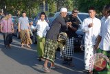 Anggota Pecalang atau satuan pengamanan adat Bali bersalaman dengan warga muslim saat pelaksanaan salat Idul Adha di Lapangan Lumintang Denpasar, Jumat (1/9). Pecalang turut dilibatkan bersama TNI dan Polri dalam pengamanan ibadah di Bali untuk memperkuat kerukunan dan toleransi antar umat beragama. Antara Foto/Wira Suryantala/nym/2017.
