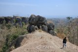 Pengunjung berada di wisata alam Betoh So'on (Batu Susun) di Desa Solor, Cermee, Bondowoso, Jawa Timur, Minggu (3/9). Batu susun solor merupakan batu besar yang tersusun rapi berdiri tegak di tengah perbukitan desa setempat dan batunya mirip dengan sebuah situs warisan dunia 'Stonehenge' di Salisbury Plain, Wilshire, Inggris. Antara Jatim/Seno/zk/17.