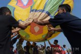 Peserta bersiap menerbangkan balon udara menggunakan asap saat digelar Festival Balon Ponorogo di Lapangan Nongkodono, Kauman, Ponorogo, Jawa Timur, Minggu (3/9).  Festival Balon Ponorogo yang baru pertama digelar  diikuti peserta dari seluruh perwakilan kecamatan di Ponorogo dengan menerbangkan 46 balon udara bertenaga asap tanpa disertai sumbu api dikendalikan tali dimaksudkan untuk mengalihkan kebiasaan masyarakat Ponorogo menerbangkan balon udara dengan tenaga asap dan api secara liar tanpa tali sehingga bisa berbahaya bagi penerbangan. Antara Jatim/Siswowidodo/zk/17