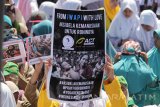 Massa membentangkan poster saat mengikuti aksi solidaritas dan kemanusian untuk Rohingya di Surabaya, Jawa Timur, Selasa (5/9). Aksi yang diikuti oleh berbagai elemen ormas keagamaan tersebut menuntut agar pemerintah mengusir Kedubes Myanmar dari Indonesia dan mendesak terwujudnya perdamaian di Myanmar. Antara Jatim/Moch Asim/zk/17