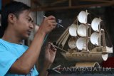 Winarso menyelesaikan pembuatan miniatur perahu layar di Desa Tulungrejo, Kediri, Jawa Timur, Selasa (5/9). Perajin miniatur berbagai bentuk seharga Rp300.000 hingga Rp1.000.000 per unit yang dipasarkan secara daring tersebut kewalahan memenuhi banyaknya pesanan dari daerah Bali. Antara Jatim/Prasetia Fauzani/zk/17