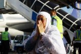 Seorang jamaah haji melakukan syukur saat tiba di tanah air di Bandara Internasional Juanda Surabaya di Sidoarjo, Jawa Timur, Kamis (7/9). Sebanyak 447 jamaah haji haji kloter pertama asal Kediri kembali ke tanah air setelah menunaikan ibadah haji. Antara Jatim/Umarul Faruq/zk/17