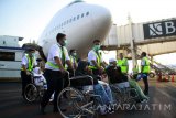 Petugas medis mendorong kursi roda jemaah haji yang sakit saat tiba di tanah air di Bandara Internasional Juanda Surabaya di Sidoarjo, Jawa Timur, Kamis (7/9). Panitia Penyelenggara Ibadah Haji (PPIH) Kantor Wilayah Kementerian Agama Jawa Timur menyiapkan alat pengukur suhu (thermo scanner) bagi jamaah haji yang sakit untuk memastikan kondisi kesehatan para jamaah haji. Antara Jatim/Umarul Faruq/zk/17