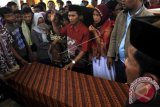 Syalwani (tengah) diidampingi isteri mengangkat tangan meminta warga tenang saat menerima peti jenazah puterinya, Timong (28) TKI yang tewas di Suriah di Kampung Puyuh Koneng, Pontang, Serang, Banten, Kamis (7/9). Timong sebelumnya dikabarkan tewas akibat dianiaya majikanya di Suriah pada 31 Juli 2017 dan setelah melalui bantuan diplomatik akhirnya jenazah korban bisa dipulangkan melalui Libanon. ANTARA FOTO/Asep Fathulrahman/ama/17