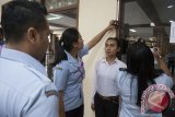 Petugas dari Kanwil Kemenkum HAM mengukur tinggi badan pelamar dalam seleksi calon pegawai negeri sipil (CPNS) Kementerian Hukum dan HAM di Denpasar, Senin (11/9). Panitia seleksi CPNS telah menerima sebanyak 7.103 peminat yang akan memperebutkan kuota untuk Bali sebanyak 199 orang bagi lulusan SMA dan Diploma serta 250 orang bagi lulusan S1. Antara Bali/Nyoman Budhiana/nym/2017.