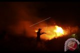 Petugas gabungan dari BPBD Ogan Ilir dan anggota Polres Ogan Ilir berusaha memadamkan api yang membakar di dekat pemukiman di Dusun II Desa Sungai Rambutan, Indralaya Utara, Ogan Ilir (OI), Sumatera Selatan, Jumat (15/9) malam. Kebakaran dikawasan tersebut hampir menghanguskan belasan rumah penduduk. Antara Foto/Nova Wahyudi/nym/2017.