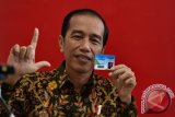 Presiden Joko Widodo menunjukkan kartu keanggotaan Perpustakaan Nasional disela peresmian di Jakarta, Kamis (14/9/2017). Presiden meminta Perpusnas mampu mengembangkan sistem digitalisasi, khususnya untuk meningkatkan minat baca kepada anak-anak generasi Y dan generasi Z yang memiliki pola pikir dan perilaku jauh berbeda dengan generasi generasi sebelumnya. (ANTARA FOTO/Puspa Perwitasari)