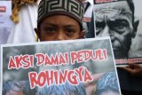 Seorang anak memegang poster ketika ikut berunjuk rasa yang digelar Aliansi Sumut Peduli Rohingya, di Medan, Sumatera Utara, Jumat (15/9). Pengunjuk rasa menuntut penghentian kekerasan militer Myanmar terhadap etnis minoritas muslim Rohingya. ANTARA FOTO/Irsan Mulyadi/pd/17.