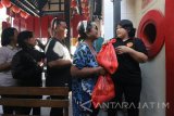 Warga menerima pembagian sembako di Klenteng Pak Kik Bio, Surabaya, Jawa Timur, Minggu (17/9). Pembagian 1.500 paket sembako kepada warga sekitar klenteng itu yang dilakukan oleh umat Tri Dharma tersebut merupakan rangkaian tradisi Sembahyang Rebutan. Antara Jatim/Didik Suhartono/mas/17