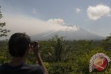 Warga memotret asap yang mulai mengepul dari kawah Gunung Agung dari Pos Pemantauan Desa Rendang, Karangasem, Bali, Selasa (19/9). Petugas pos pemantauan Gunung Agung telah mencatat tingkat kegempaan meningkat drastis dari 180 kali menjadi 366 kali dalam 24 jam terakhir. ANTARA FOTO/Nyoman Budhiana/wdy/2017.