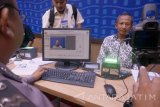 Petugas melakukan perekaman identitas dan foto pemohon baru maupun perpanjangan surat izin mengemudi (SIM) di Kantor Satuan Penyelenggara Administrasi SIM (Satpas) Polres Tulungagung.Antara jatim/Destyan Sudjarwoko/ma/17