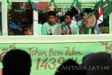 Sejumlah peserta 'Parade 99 Bedug' berada di atas mobil hias melintasi rute yang telah ditentukan di Kota Kediri, Jawa Timur, Kamis (21/9). Kegiatan yang diadakan oleh Nahdlatul Ulama (NU) tersebut guna memeriahkan tahun baru islam 1439 Hijriyah. Antara Jatim/Prasetia Fauzani/17.
