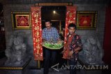 Seorang warga mengambil tumpeng Suro-an milik warga keturunan Tionghoa yang telah didoakan di Tempat Ibadah Tri Dharma (TITD) Hong San Ko Tee di Surabaya, Jawa Timur, Kamis (21/9). Ratusan tumpeng Suro-an yang dikumpulkan tersebut sebagai rasa syukur atas rejeki dan kesehatan dari Tuhan Yang Maha Esa dalam ritual memperingati tahun baru Jawa 1 Suro. Antara Jatim/M Risyal Hidayat/mas/17