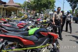 Polisi memeriksa sepeda motor yang terjaring operasi Pengamanan Aman Suro 2017 di halaman Polres Kota Madiun, Jawa Timur, Jumat (22/9). Polres Kota Madiun menilang 150 sepeda motor dan menahan 80 sepeda motor milik para pesilat karena melakukan pelanggaran mengendarai sepeda motor saat melakukan ziarah ke makam pendiri dan sesepuh perguruan silat di Kota Madiun. Sesuai kesepakatan, seluruh anggota dua perguruan silat, Persaudaraan Setia Hati Terate (PSHT) dan Persaudaraan Setia Hati Tunas Muda (PSHTM) Wonongo yang melakukan kegiatan selama bulan Suro di Madiun dilarang mengendarai sepeda motor. Antara Jatim/Siswowidodo/mas/17.