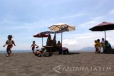 Pengunjung menikmati suasana di Pantai Cacalan,Banyuwangi, Jawa Timur, Sabtu (23/9). Pantai Cacalan merupakan destinasi wisata baru di pusat kota Banyuwangi yang dapat dijadikan alternatif mengisi liburan. Antara Jatim/Budi Candra Setya/mas/17.