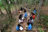 Relawan mendampingi anak-anak menulis proses mencapai cita-citanya di sekolah alam Kampung Batara di Papring, Banyuwangi, Jawa Timur, Minggu (24/9). Kegiatan edukasi tersebut bertujuan untuk memperkuat literasi pada anak-anak sekolah alam yang terletak di pinggir hutan produksi perhutani. Antara Jatim/Budi Candra Setya/uma/17.