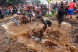 Para petani yang didandani kerbau berkeliling desa mengikuti empat penjuru mata angin dan melakukan ritual layaknya siklus bercocok tanam, mulai dari membajak sawah, mengairi, hingga menabur benih padi. Mereka kemudian berjubang lumpur ditengah sawah yang sudah dipersiapkan. Antara Jatim/Budi Candra Setya/uma/17.