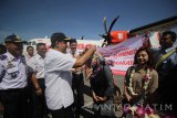 Wakil Gubernur Jawa Timur Saifullah Yusuf (kedua kiri) mengalungkan karangan bungan kepada penumpang pesawat ATR 72-600 saat pembukaan penerbangan perdana Wings Air Surabaya-Sumenep di Bandara Internasional Juanda Surabaya di Sidoarjo, Jawa Timur, Rabu (27/9). Maskapai Wings Air membuka rute baru untuk penerbangan dari Bandara Internasional Juanda Surabaya di Sidoarjo menuju Bandara Trunojoyo, Sumenep atau sebaliknya guna membuka konektivitas daerah di seluruh Indonesia untuk kemandirian ekonomi. Antara Jatim/Moch Asim/17.