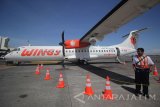 Petugas berdiri di samping pesawat ATR 72-600 saat pembukaan penerbangan perdana Wings Air Surabaya-Sumenep di Bandara Internasional Juanda Surabaya di Sidoarjo, Jawa Timur, Rabu (27/9). Maskapai Wings Air membuka rute baru untuk penerbangan dari Bandara Internasional Juanda Surabaya di Sidoarjo menuju Bandara Trunojoyo, Sumenep atau sebaliknya guna membuka konektivitas daerah di seluruh Indonesia untuk kemandirian ekonomi. Antara Jatim/Moch Asim/17.