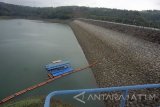 Pengunjung berjalan di atas bendung (waduk) Wonorejo, Tulungagung, Jawa Timur, Rabu (27/9). Selama kemarau, cadangan air waduk pengendali banjir, irigasi serta pembangkit listrik tenaga  air (PLTA) di kaki Gunung Wilis itu menyusut hingga batas elevasi 167,40 meter atau tersedia sekitar 56 juta meter kubik dari total batas kapasitas tampung (penuh) sekitar 106 juta meter kubik pada kondisi penghujan. Antara Jatim/Destyan Sujarwoko/mas/17.