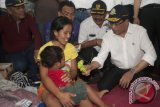 Menteri Perhubungan Budi Karya Sumadi (kanan) memberi hadiah kepada anak pengungsi saat meninjau tempat penampungan pengungsi Gunung Agung di GOR Suwecapura, Klungkung, Bali, Kamis (28/9). Berdasarkan data Badan Nasional Penanggulangan Bencana (BNPB), hingga saat ini jumlah pengungsi Gunung Agung telah mencapai 104.673 orang yang tersebar di berbagai lokasi di seluruh Bali. ANTARA FOTO/Nyoman Budhiana/wdy/2017.