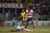 Penjaga gawang Persegres Gresik United Satria Tama (kiri) menghadang laju dari pesepak bola Madura United FC Greg Nwokolo (kanan) dalam lanjutan Gojek Traveloka Liga 1 di Stadion Petrokimia Gresik, Jawa Timur, Selasa (26/9). Persegres Gresik United dikalahkan Madura United FC dengan skor 0-3. Antara Jatim/M Risyal Hidayat/mas/17.