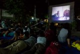 Anak-anak beserta warga lainnya menyaksikan pemutaran film peristiwa pengkhianatan G30S/PKI di kawasan Kota Lama, Semarang, Jawa Tengah Rabu (27/9) malam. Nonton bareng (nobar) yang diselenggarakan oleh Pomdam IV/Diponegoro itu untuk mengedukasi masyarakat agar tidak melupakan sejarah bangsa dan menumbuhkan rasa kecintaan terhadap Negara Kesatuan Republik Indonesia, nasionalisme sekaligus untuk menghindari peristiwa pengkhianatan terhadap negara kembali terjadi. ANTARA FOTO/Aji Styawan/pd/17.