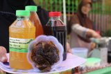 Warga menunjukkan berbagai produk olahan dari buah Belimbing Wuluh di Kampung Lawas Maspati, Surabaya, Jawa Timur, Kamis (28/9). Produk olahan menyehatkan seperti manisan, sirup, minuman segar dan obat batuk dari buah Belimbing Wuluh itu dijual dengan harga Rp5.000 sampai Rp15.000 per kemasan. Antara Jatim/Didik Suhartono/mas/17.